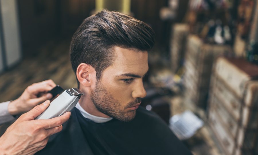 male-barber-cutting-hair-of-customer-in-barber-shop.jpg